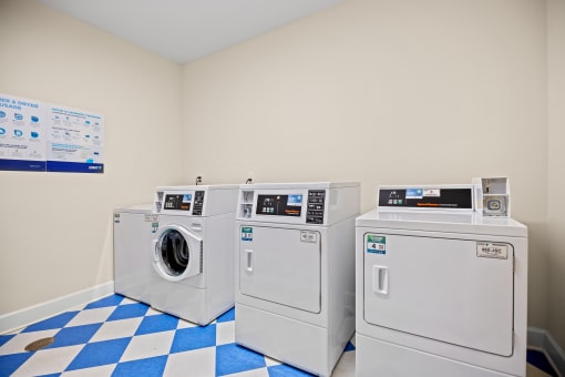a laundry room with four washing machines and a blue and white checkered floor