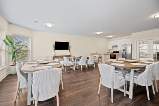 a dining room with tables and chairs and a kitchen