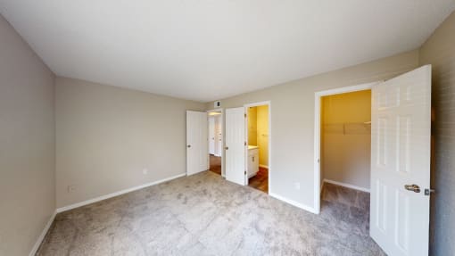 a bedroom with a bathroom in the background