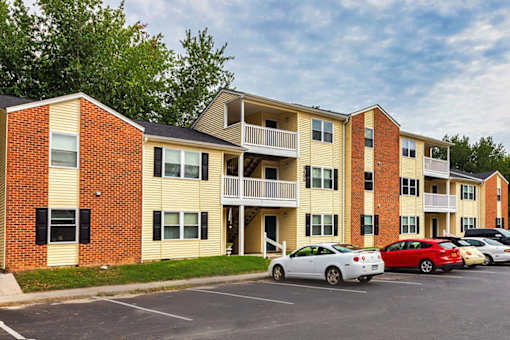 A parking lot with cars and apartment buildings.