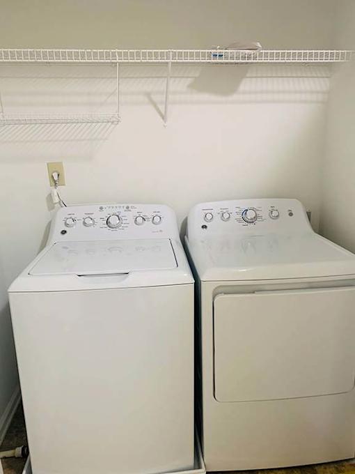 Two white washing machines in a laundry room.