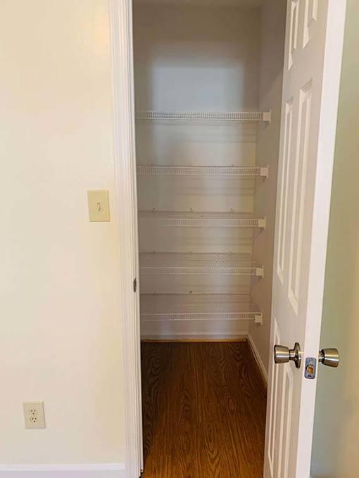 A white door with a silver handle is open to a hallway with a number 1 on the wall.