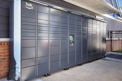 A row of Amazon hub storage units are lined up on a sidewalk.