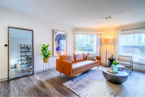 A living room with a brown sofa and a grey coffee table.