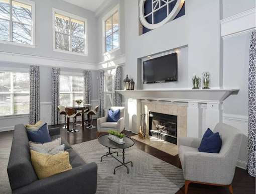 A living room with a grey couch, a fireplace, and a television.