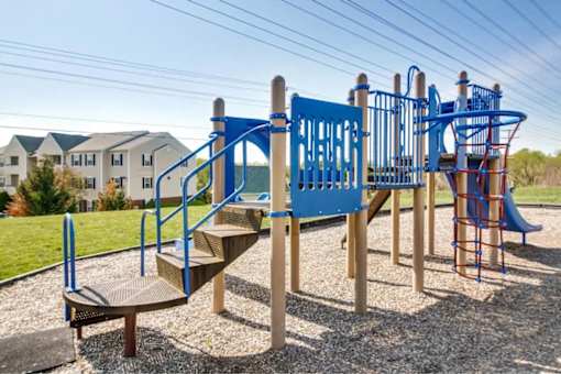 A playground with a blue slide and a wooden structure.