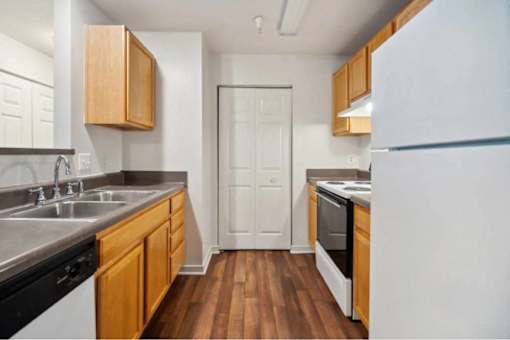 A kitchen with wooden cabinets and a white refrigerator.