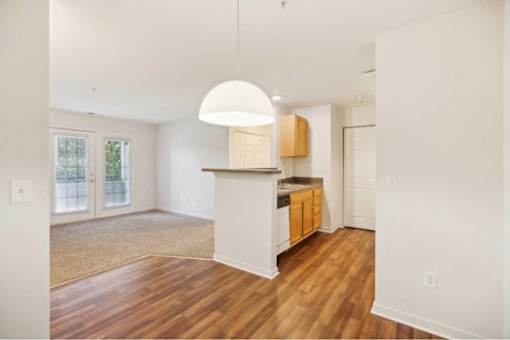 A kitchen with wooden floors and white walls.