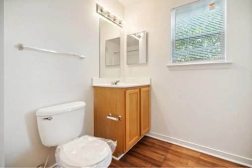 A white toilet sits next to a wooden cabinet in a bathroom.