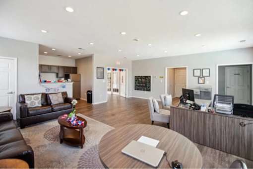 A modern living room with a black leather couch and a wooden coffee table.