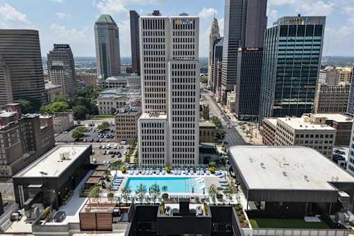 A cityscape with a pool in the foreground and tall buildings in the background.