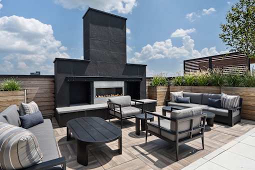 A modern outdoor seating area with a fireplace.