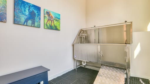 a kitchen with a stainless steel refrigerator and paintings on the wall
