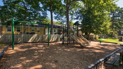 a playground with a slide and monkey bars in front of a house