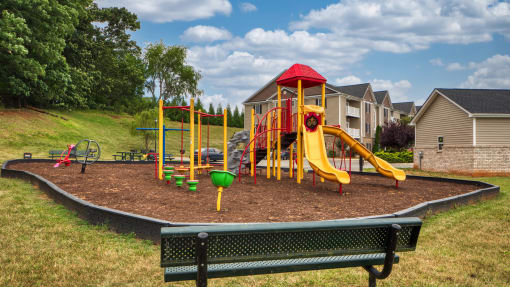 a childrens play area with a playground and a bench