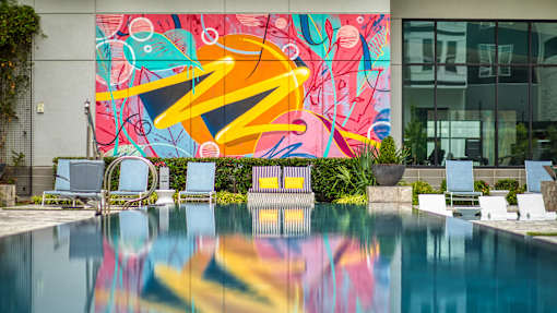 A pool with a mural on the wall behind it.