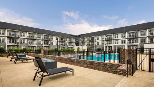 a swimming pool with lounge chairs in front of an apartment building at Ainsworth, Richmond