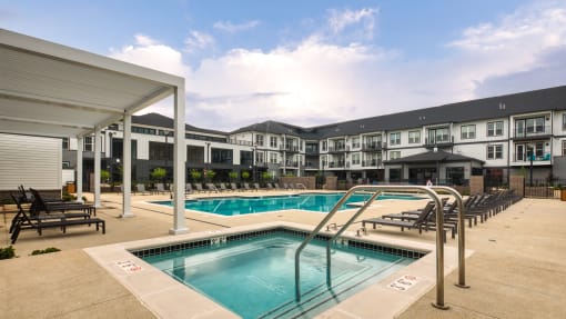 a swimming pool with chairs and a building in the background at Ainsworth, Virginia, 23228