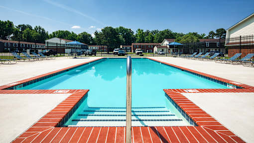 A large rectangular pool with a red tile edge and a blue water surface.