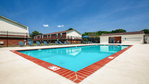 A large swimming pool with a red border and a white sign on the side.