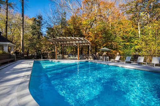 A swimming pool surrounded by trees in autumn.