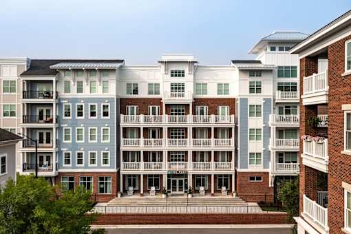 A row of apartment buildings with balconies and doors.