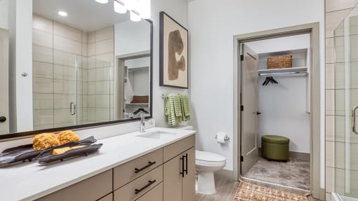 a bathroom with a large mirror and a toilet and a showerat Aura Stonebridge, Richmond, VA