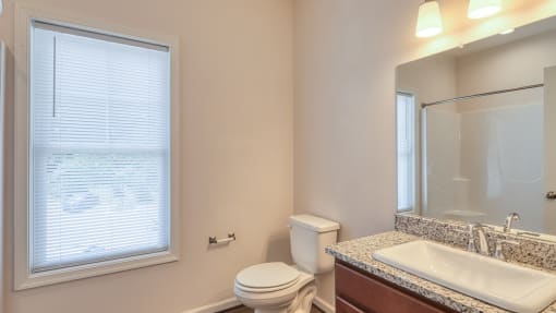 a bathroom with a sink toilet and a large window
