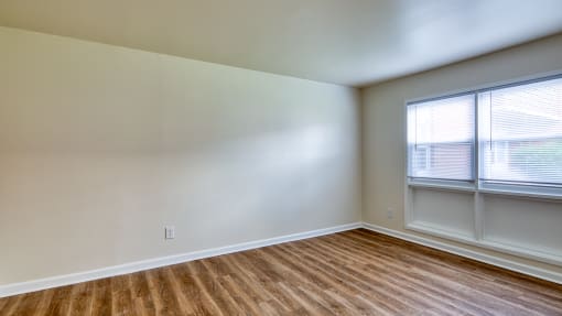 an empty room with wood flooring and two windows at Gates of West Bay in VA 23503