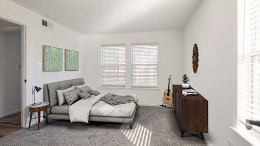 A bedroom with a bed, a nightstand, and a guitar.