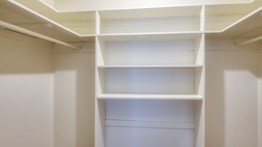 a walk in closet with white shelving and white walls at Gates of West Bay in Norfolk, VA 23503