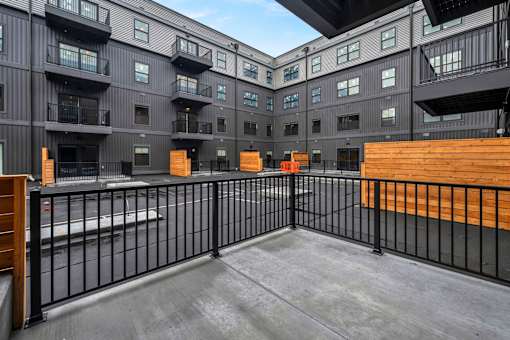 A black and white building with a balcony and a black fence.