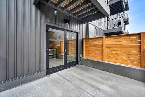 A modern building with a wooden fence and glass doors.