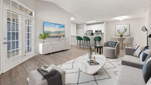 A living room with a white sofa, a coffee table, and a painting on the wall.