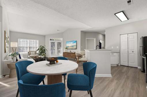A dining room with a round table and blue chairs.
