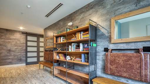 A room with a bookshelf and a mirror on the wall.