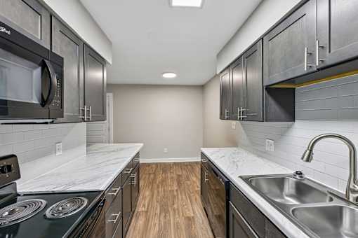 A kitchen with dark cabinets and a white counter top.