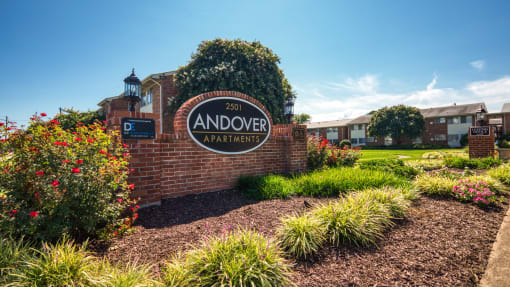 the sign apartments in front of a brick wall