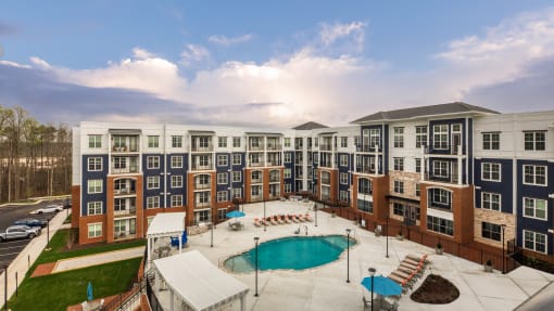 an aerial view of an apartment building with a swimming pool at The Bella at Westchester, Midlothian, VA