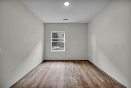 A room with a window and wooden flooring.