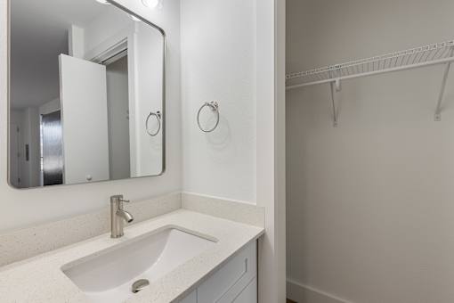 A white bathroom sink with a mirror above it.