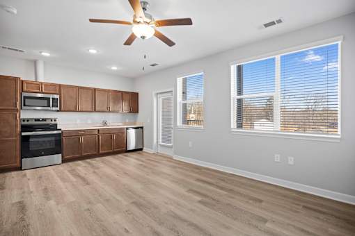 A kitchen with wooden cabinets and a ceiling fan.