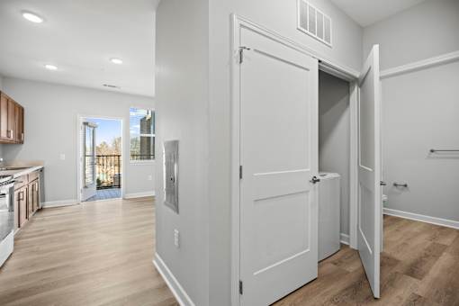 A white door is open in a room with wood flooring.