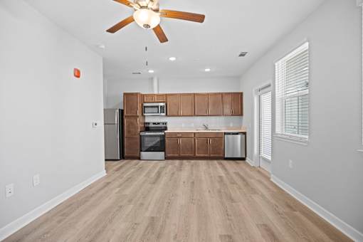 A kitchen with wooden cabinets and a ceiling fan.