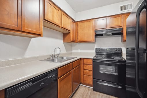 an empty kitchen with black appliances and wooden cabinets