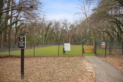 a dog park with a bench and a fence