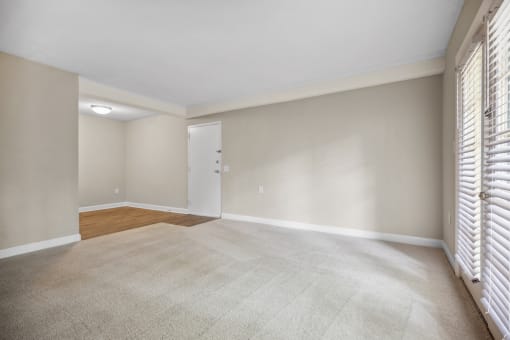 an empty living room with blinds on the window