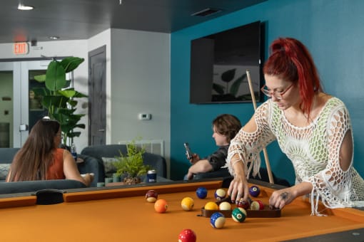 a woman playing a game of billiards on a pool table at Proximity at ODU in Norfolk, VA