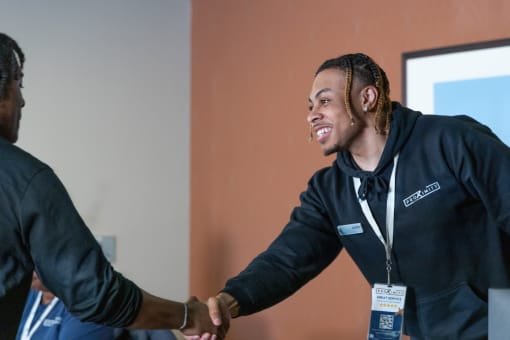 a man shaking another mans hand at a networking event at Proximity at ODU in VA 23508