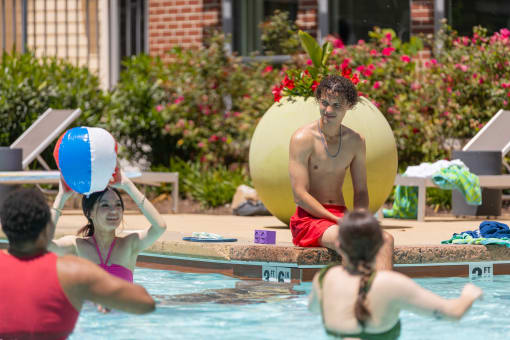 a group of people playing volleyball in the pool at Proximity at ODU in Norfolk, Virginia